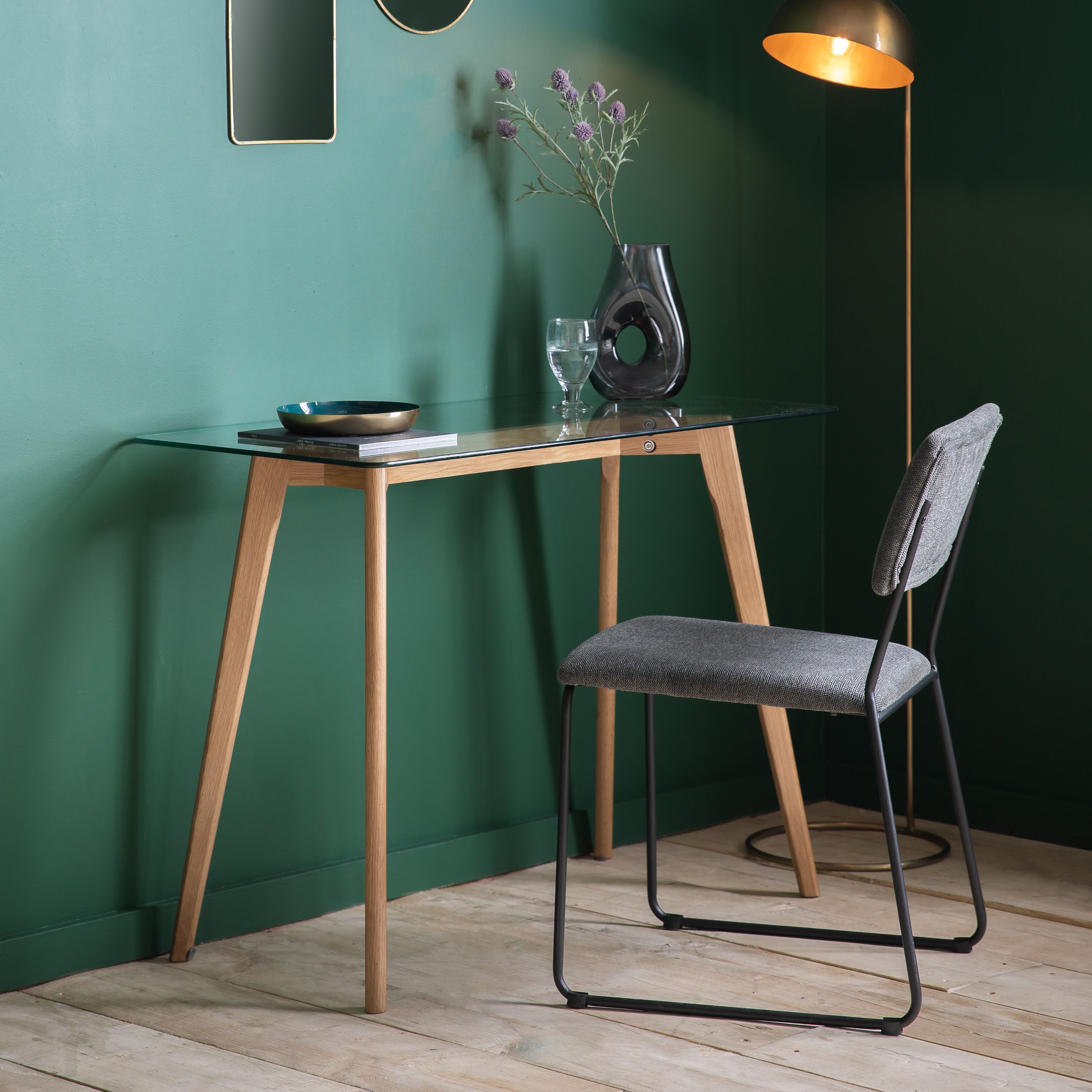 Glass-topped dining table with wooden legs.